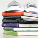 pile of books and lap top